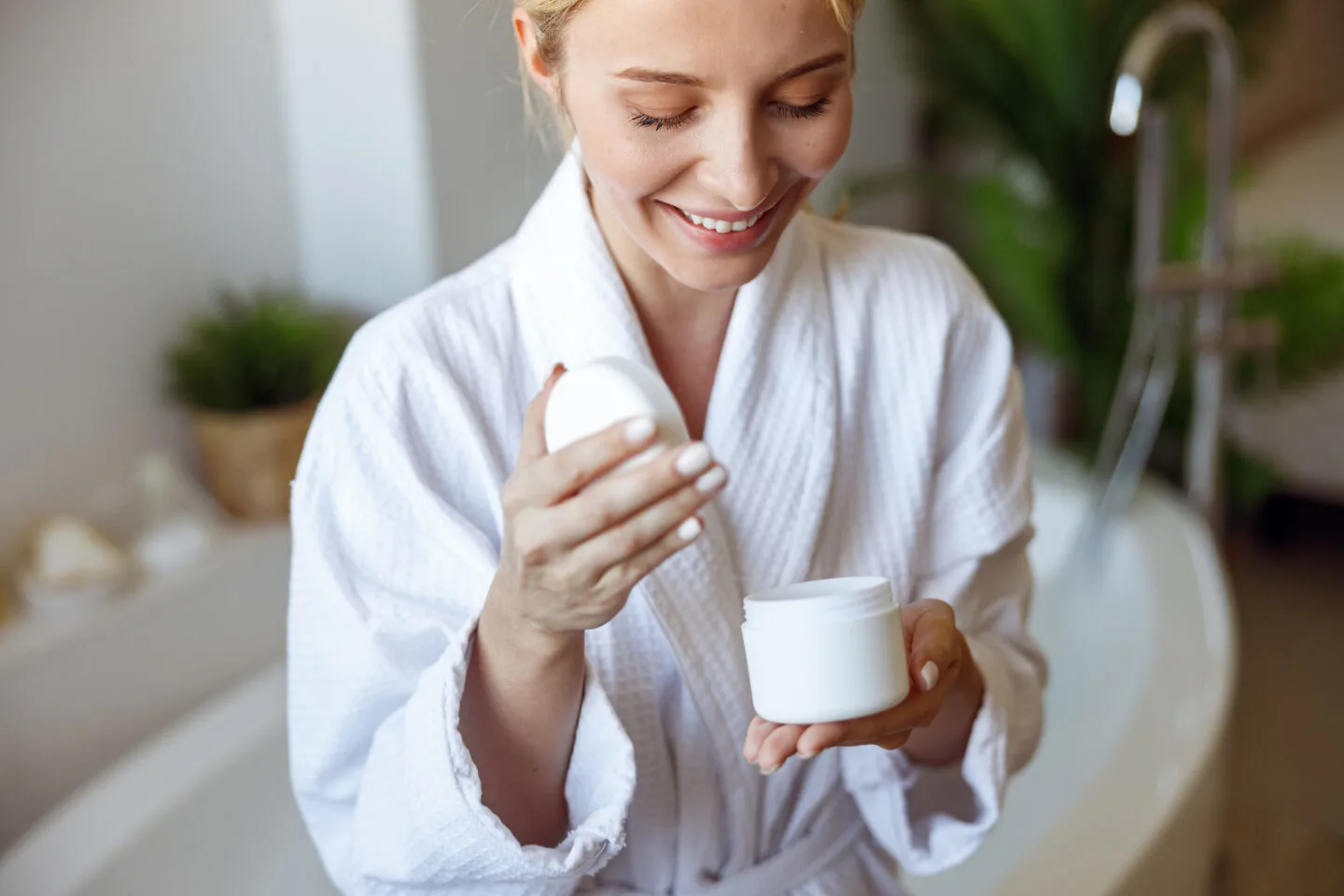 A lady looking into a jar of body butter before applying it to the skin