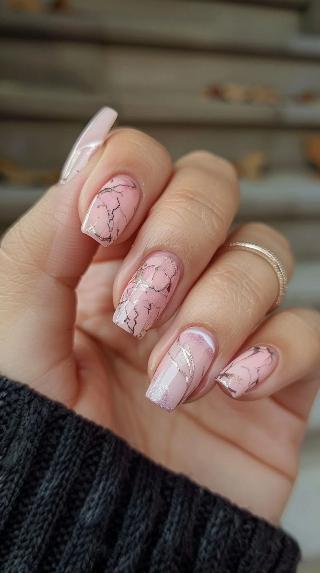 These nails combine a pale pink base with elegant white marbling and glitter accents. The blend of textures and shades creates a refined and chic appearance, ideal for adding a touch of sophistication to any outfit.