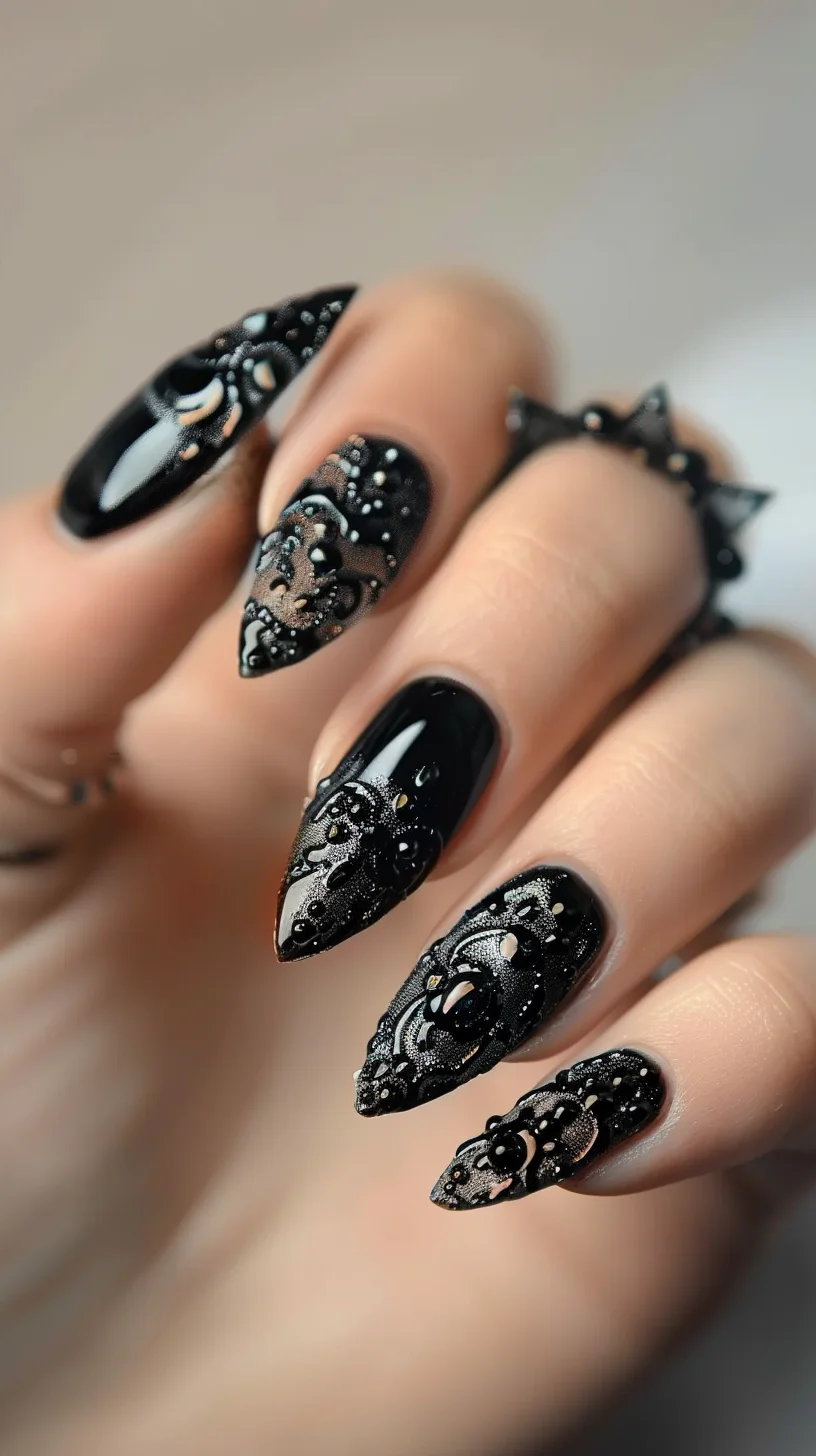 Combining a glossy black polish with intricate black lace patterns, these nails are adorned with small black beads for added texture. The lace designs cover the entire nail, creating a luxurious and detailed appearance. The nails are long and stiletto-shaped, adding to the dramatic effect.