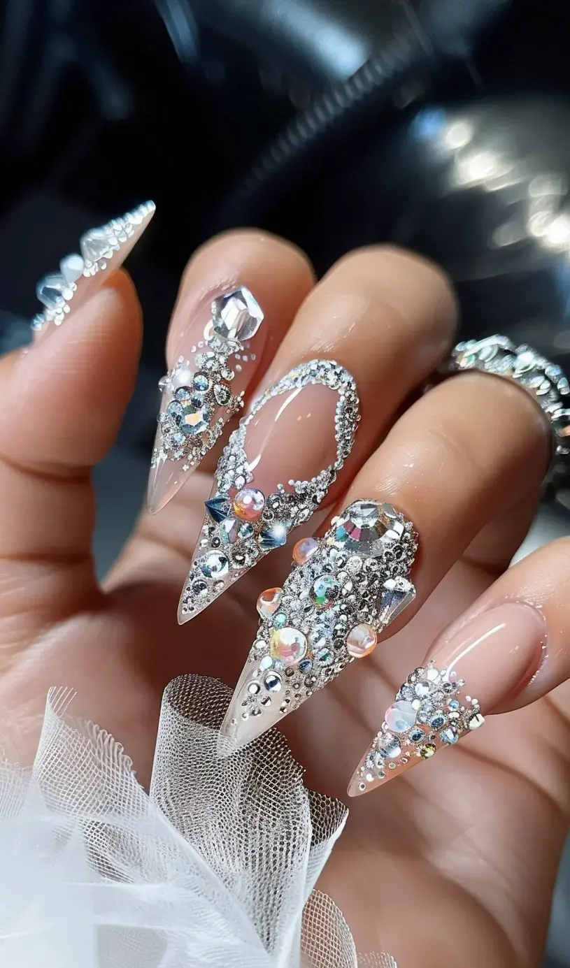 A mix of clear and colorful crystals adorns these nails, creating a dynamic and playful look. The variety of gem sizes and shapes, along with the strategic placement, gives these nails a unique and festive appearance, ideal for celebrations and parties.