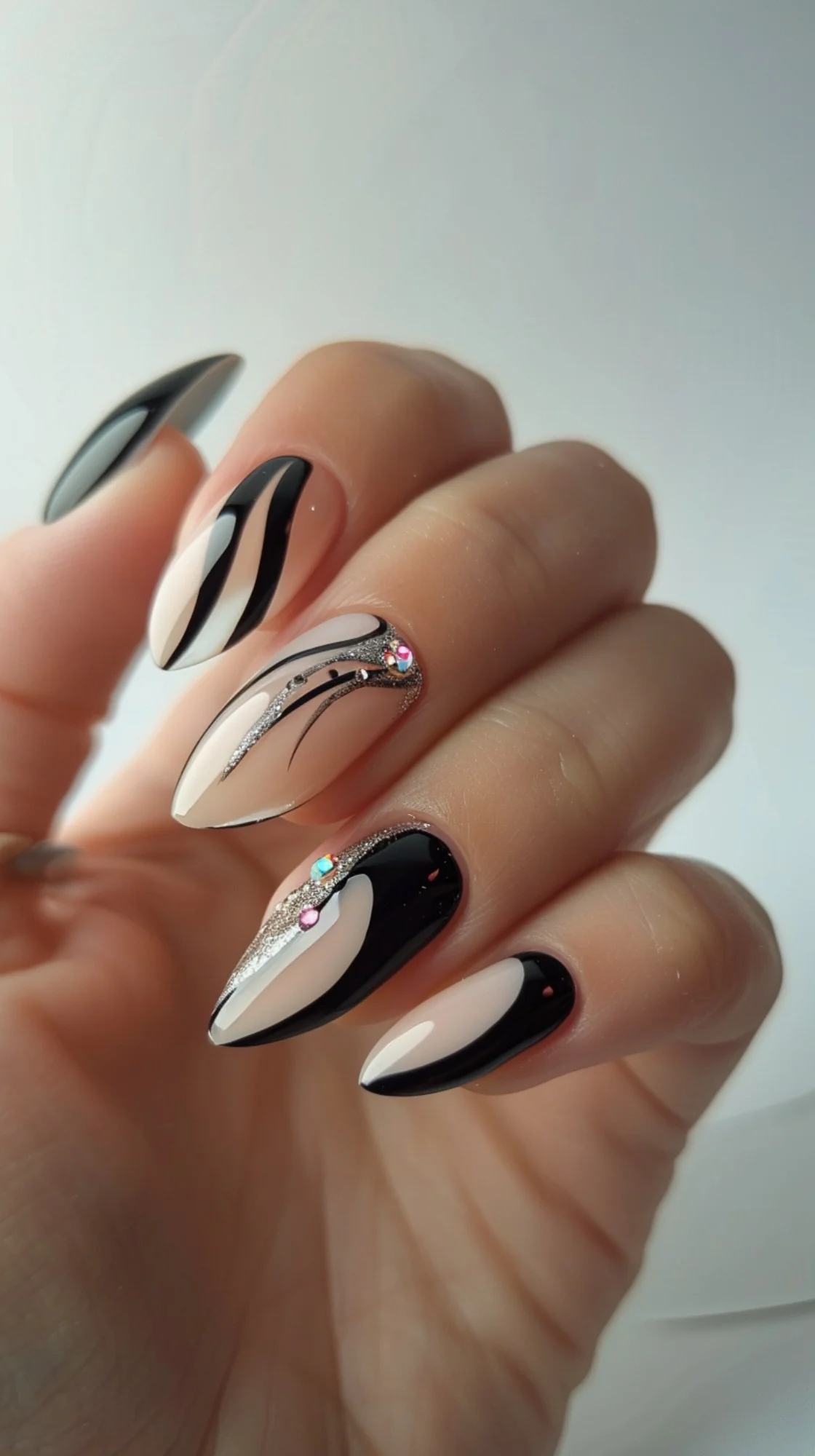 This design showcases a combination of black and nude tones with glitter accents. The curved lines and subtle rhinestones add a touch of elegance and sparkle to this classy manicure.