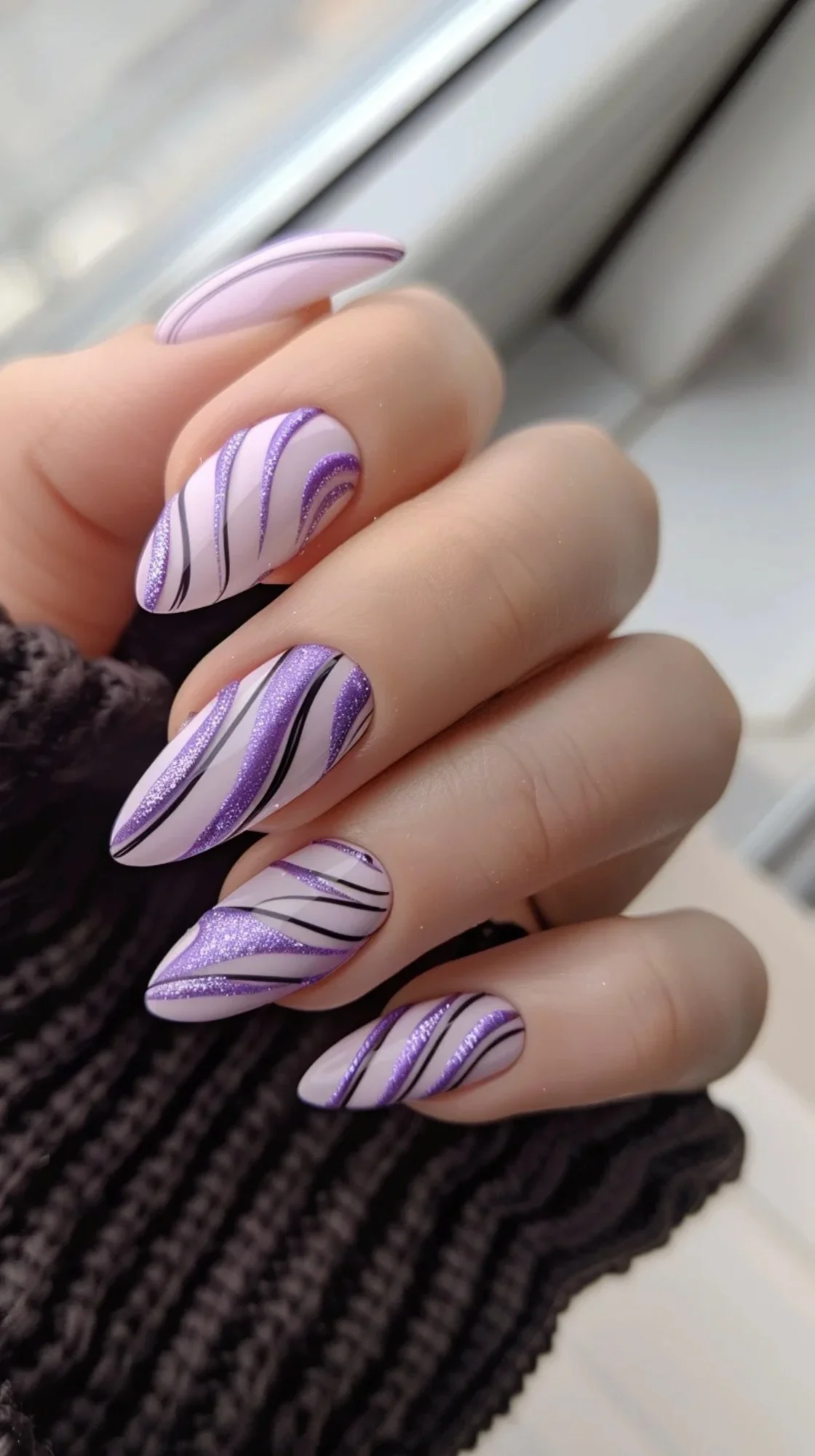 These nails boast a unique design with swirls of light purple and darker shades. The intricate pattern is accentuated with fine glitter, giving the nails a dynamic and artistic appearance, ideal for those who love creative designs.